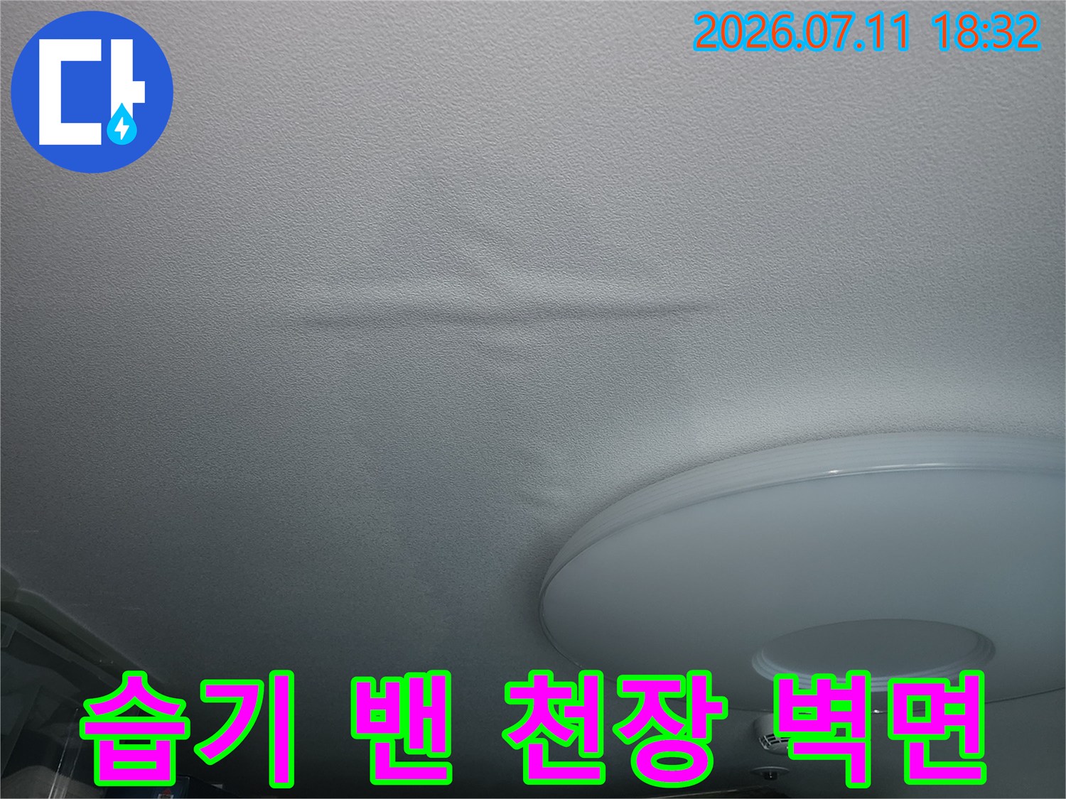흰색 마감재 위로 습기가 스며들어 변색된 배관 근처의 모습