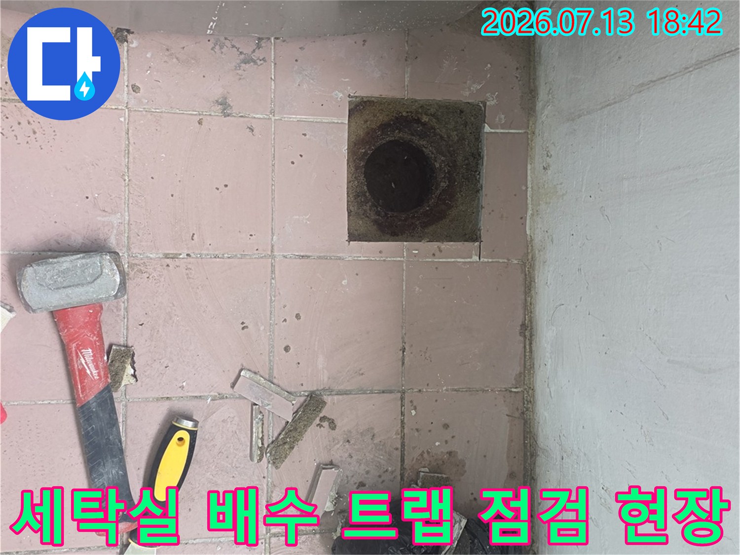 노출된 세탁실 배수관과 공구들이 배치된 작업 공간