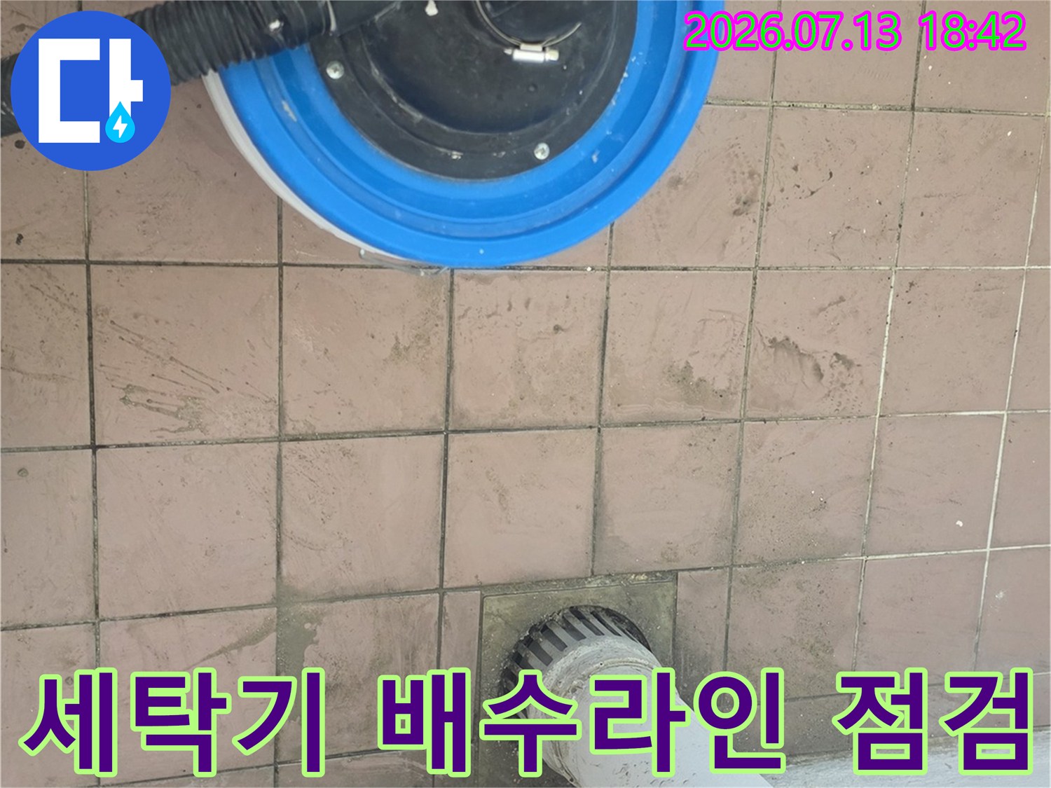 파란색 덮개가 씌워진 배수구와 세탁 호스가 결합된 구조의 누수 진단 모습