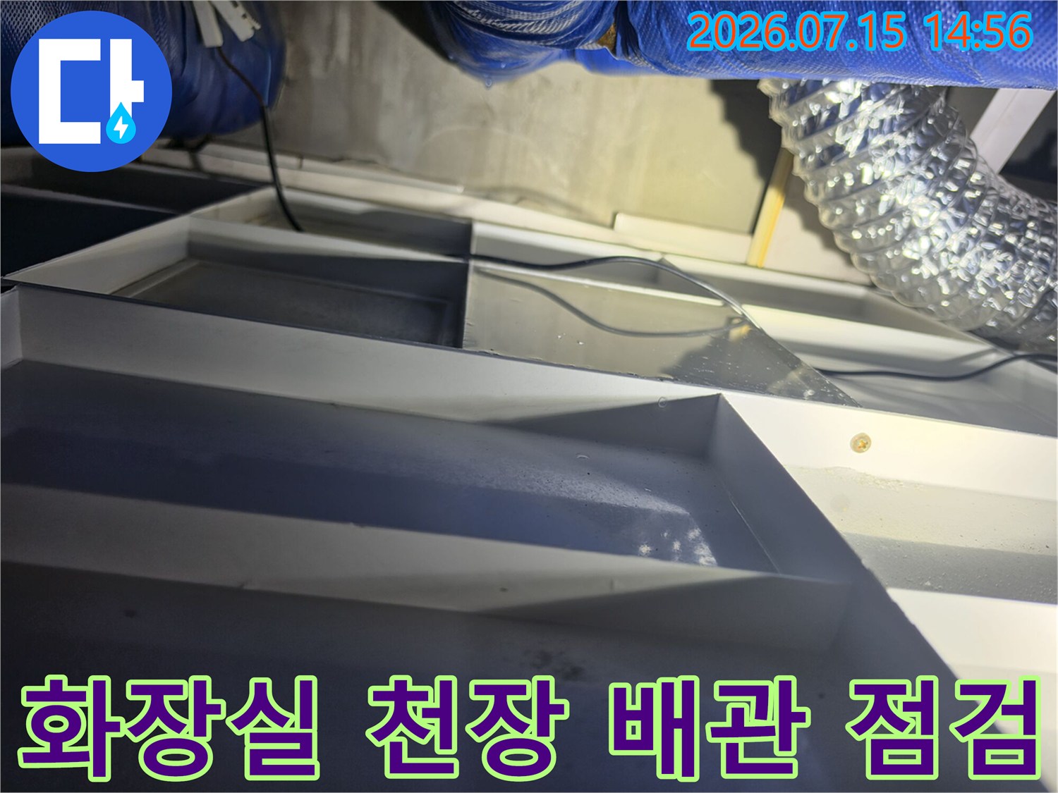 화장실 천장 내부를 열어 노출된 배관과 구조물을 세밀하게 점검하는 모습