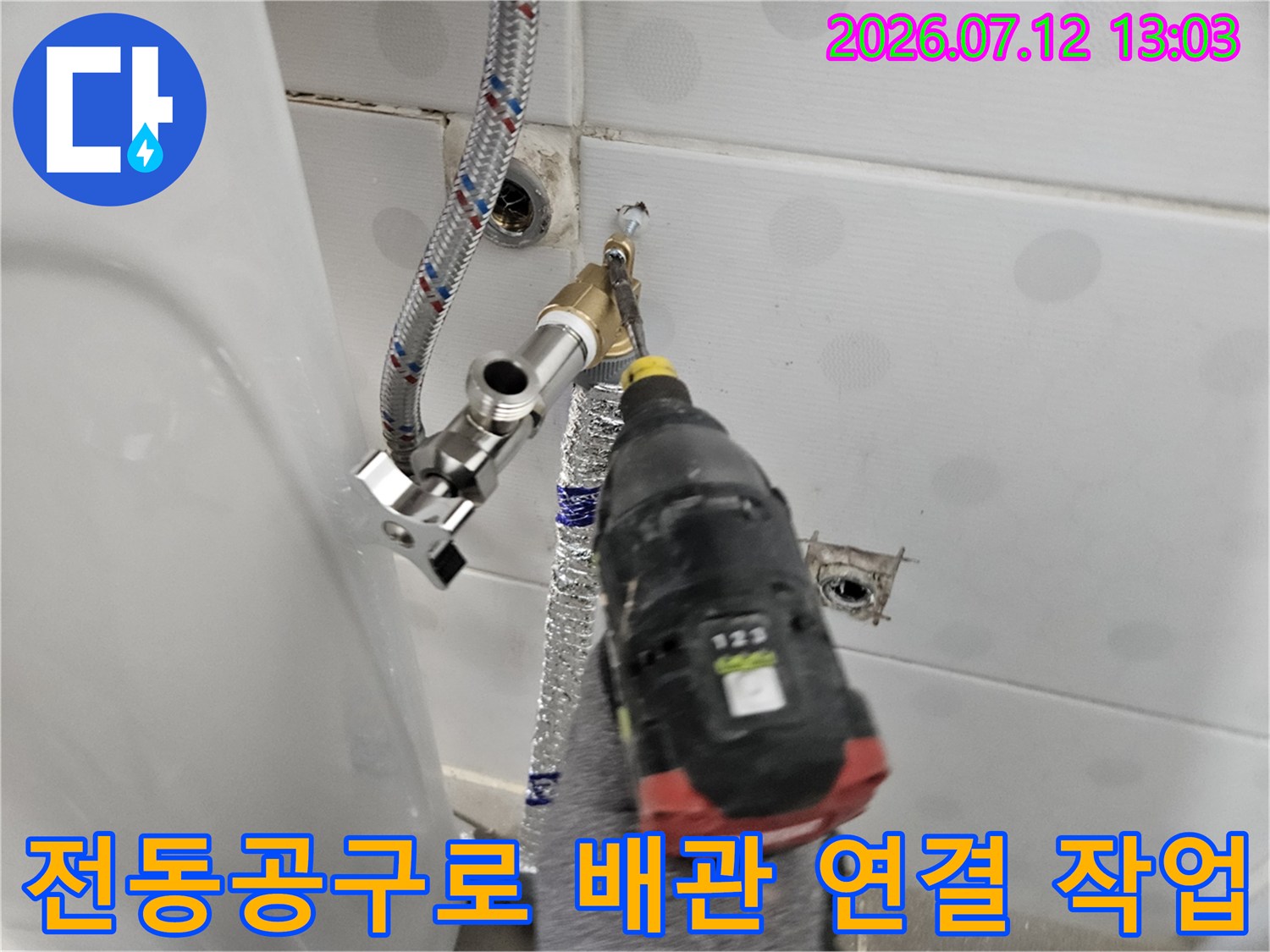 드릴을 사용하여 노출된 직수 배관과 세면대 부속을 연결하는 현장 모습