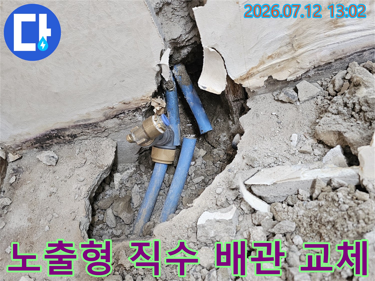 먼지 묻은 벽면을 뚫고 설치된 견고한 파란색 노출 배관 시스템