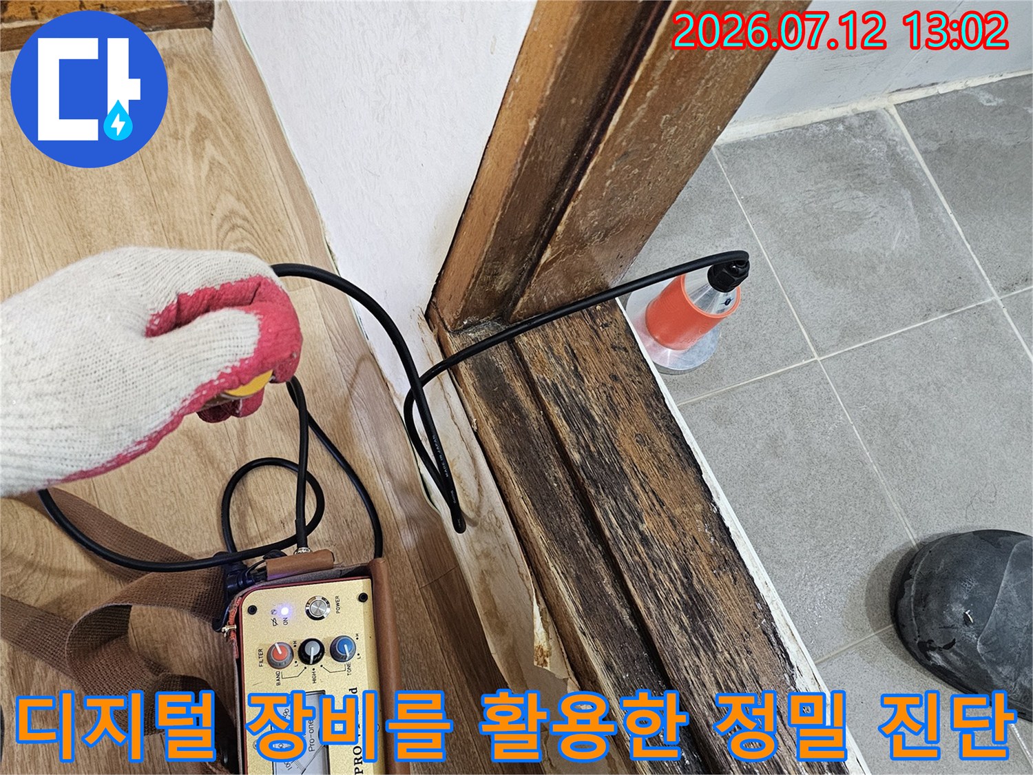 특수 탐지기를 배관 근처에 위치시켜 누수 지점을 찾아내는 장면