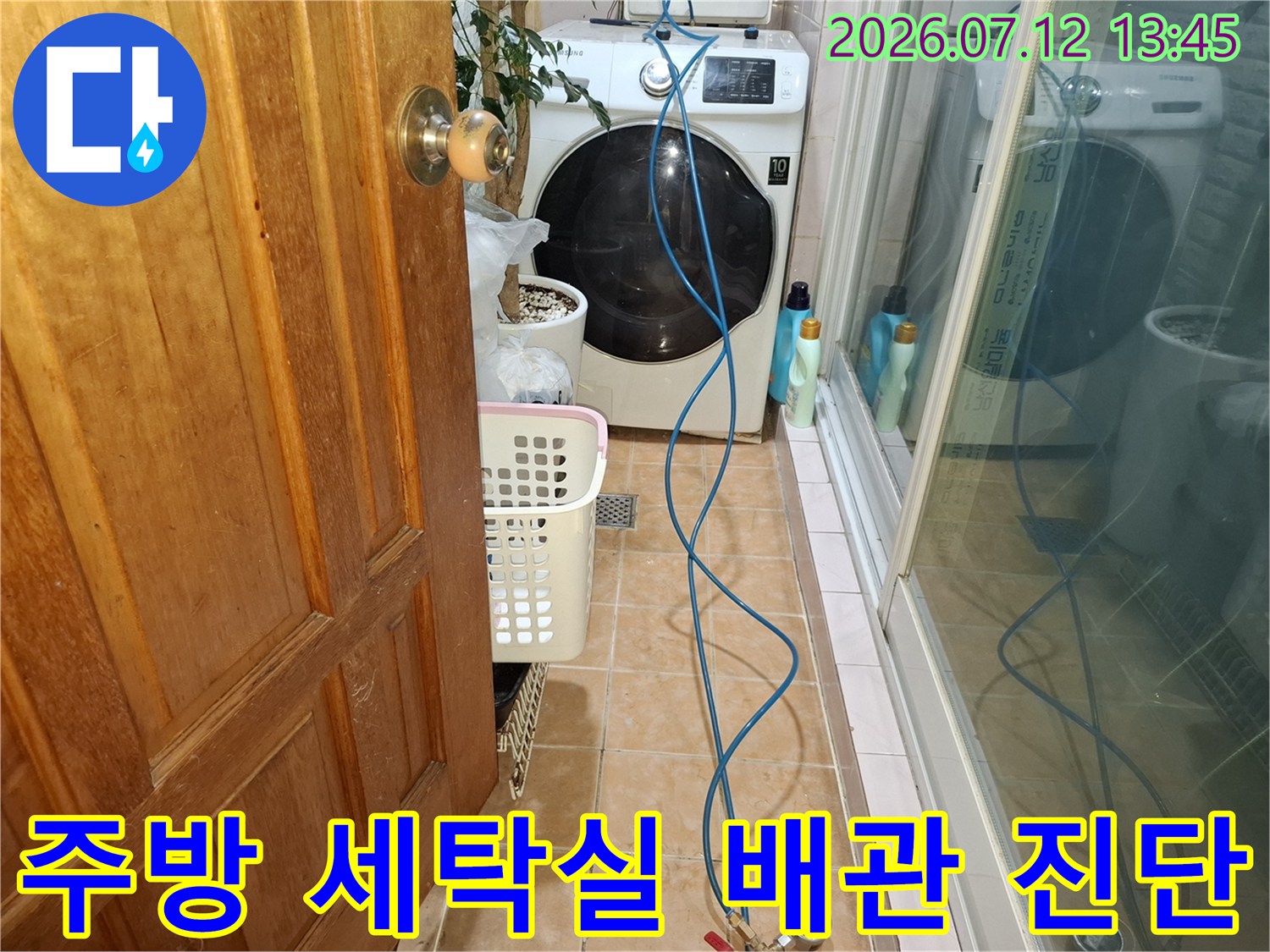 세탁기 옆에 배치된 파란색 호스와 탐지 장비를 이용한 누수 점검 현장