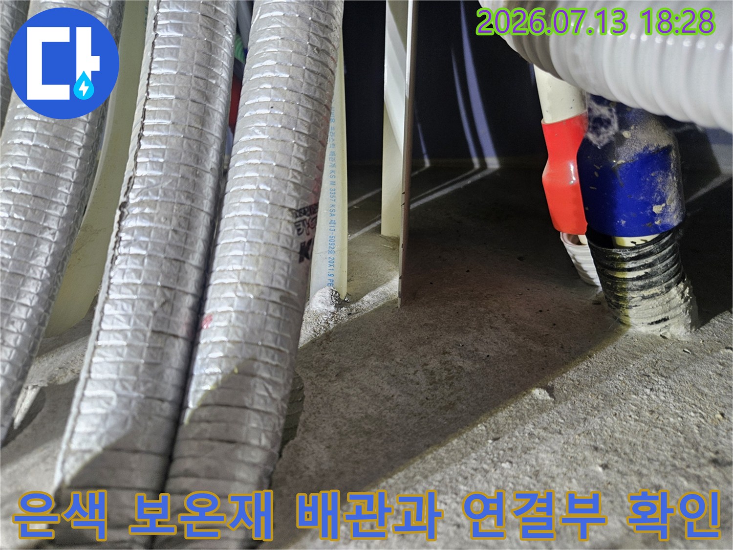 노출된 세탁실 배관의 은색 단열재 및 파란색 고정 밴드 부위 점검