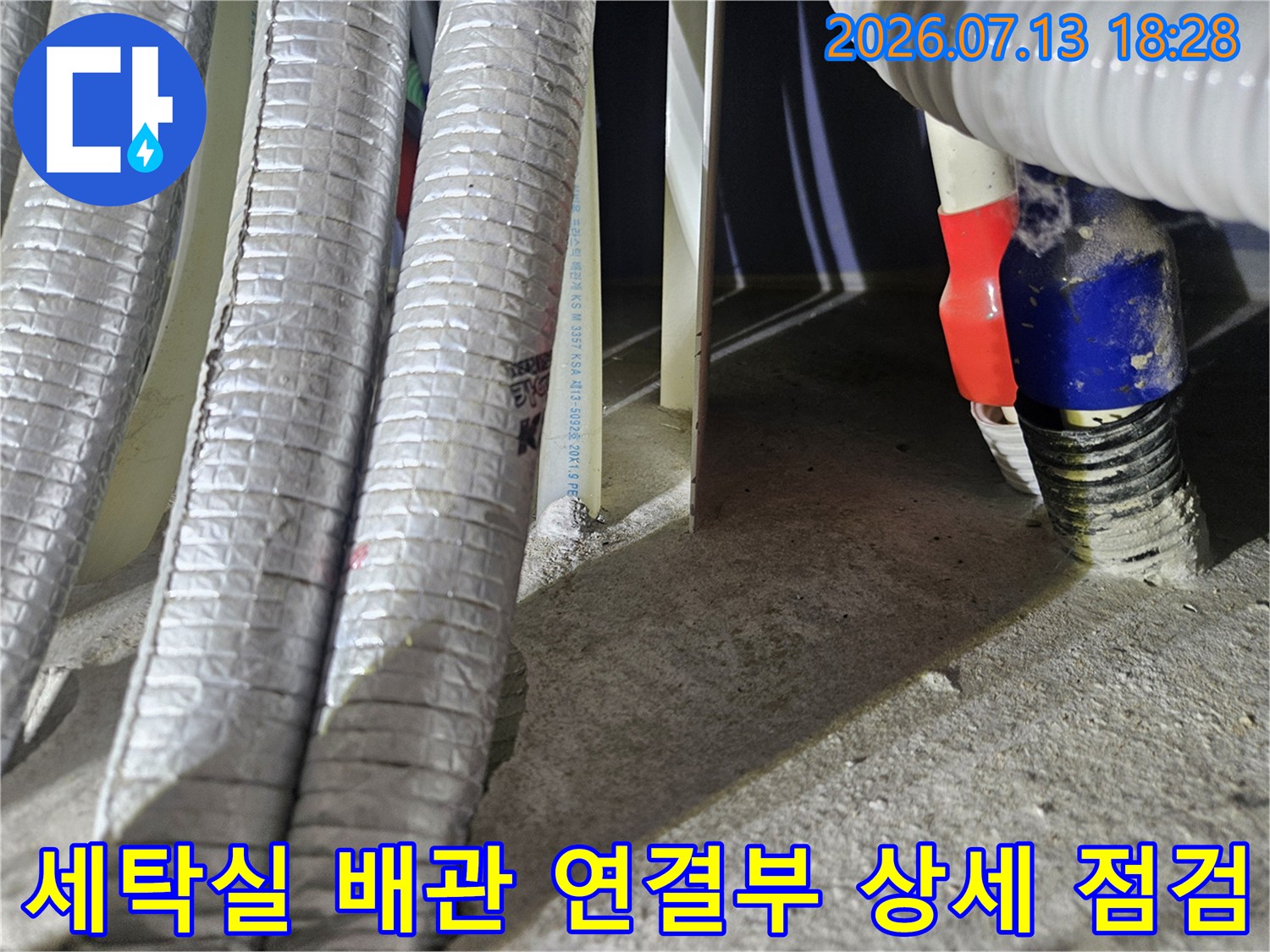 은색 단열 시트와 파란색 캡으로 구분된 여러 배관의 노출 구간