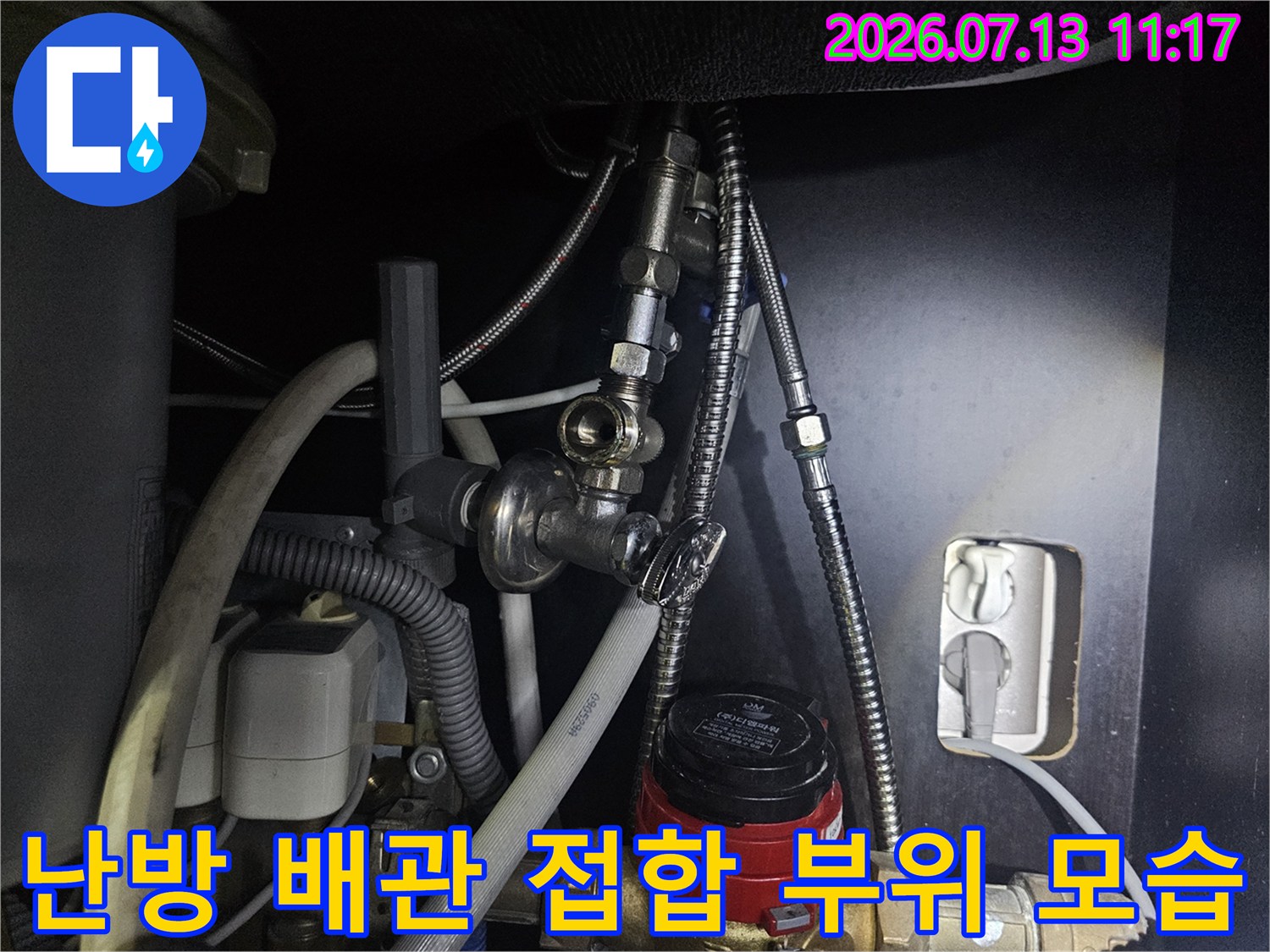 보일러 하단부의 금속제 유연 호스와 밸브-결합 지점 상세 사진