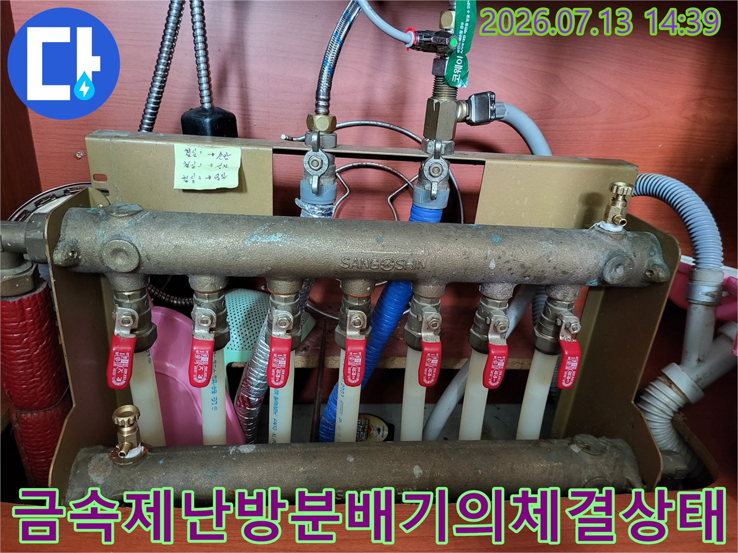 여러 개의 배관과 빨간색 밸브가 연결된 금속제 보일러 분배기 장치