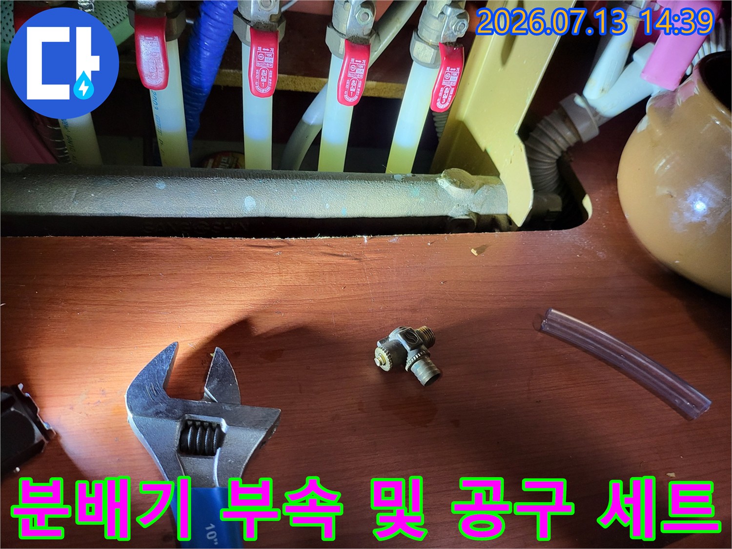 파란색-손잡이의-몽키스패너와-금속-연결-커넥터가-놓여있는-현장-모습
