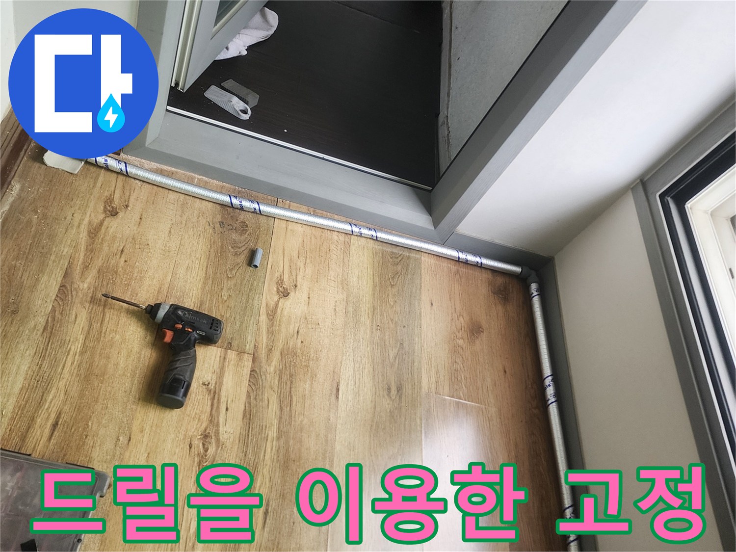 배관 설치를 위해 바닥에서 작업 중인 전동 드릴과 공구함
