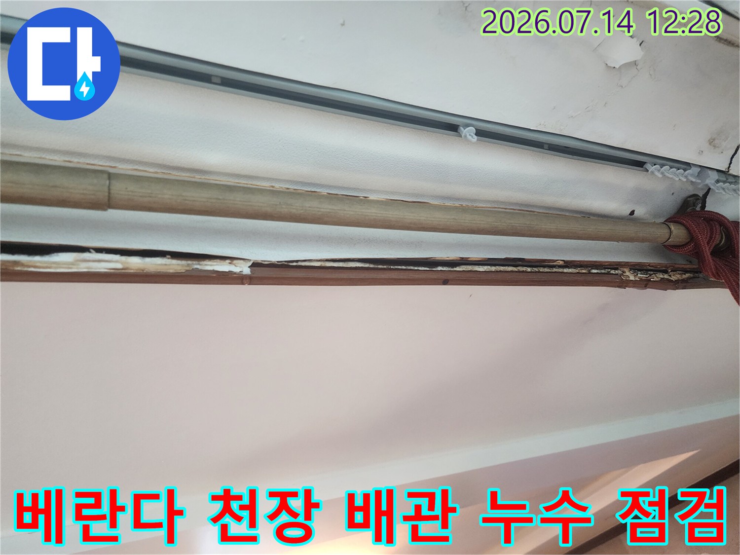 천장 내부의 노출된 드레인 호스와 파손된 배관 구간을 근접 촬영한 모습