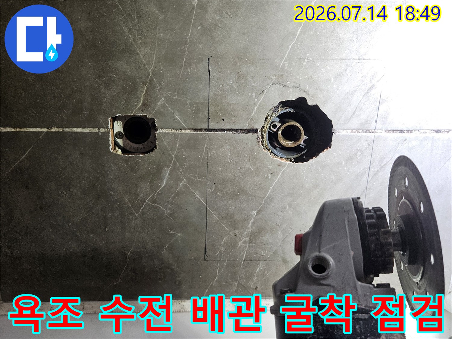 그라인더 장비를 사용하여 욕조 수전 주변의 타일을 제거하고 내부 배관을 노출시킨 모습