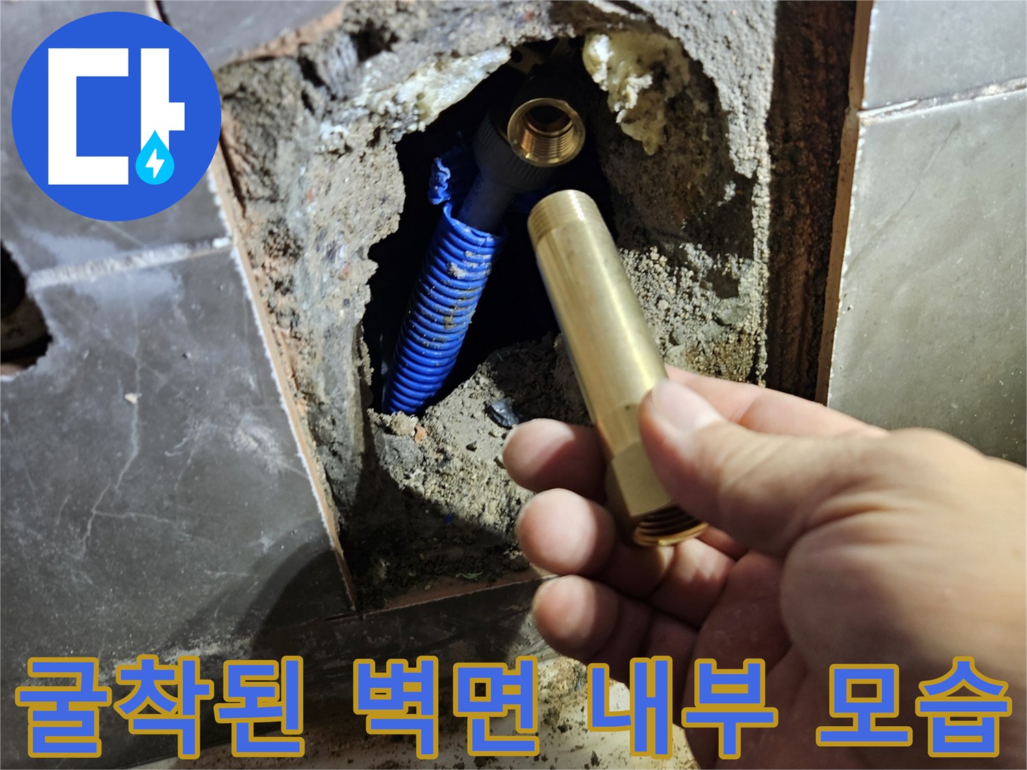 타일을 깨고 드러난 벽 속의 수전 연결 부속과 배관