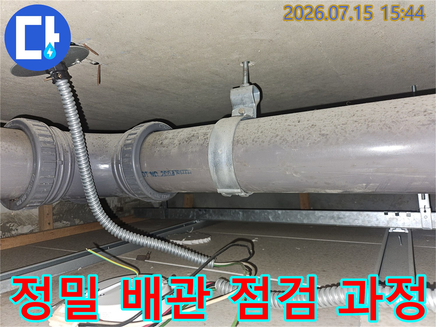 금속 파이프와 보호 호스가 얽힌 환경에서 진행된 배관 설비 정밀 점검 사진