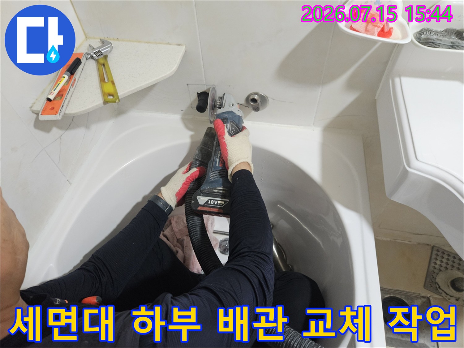 세면대 아래 노출된 온수 배관을 전문 장비를 활용해 보수하는 모습
