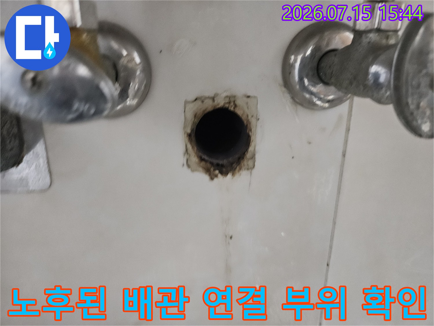 세면대 아래 노출된 파손된 배관과 주변 오염 흔적