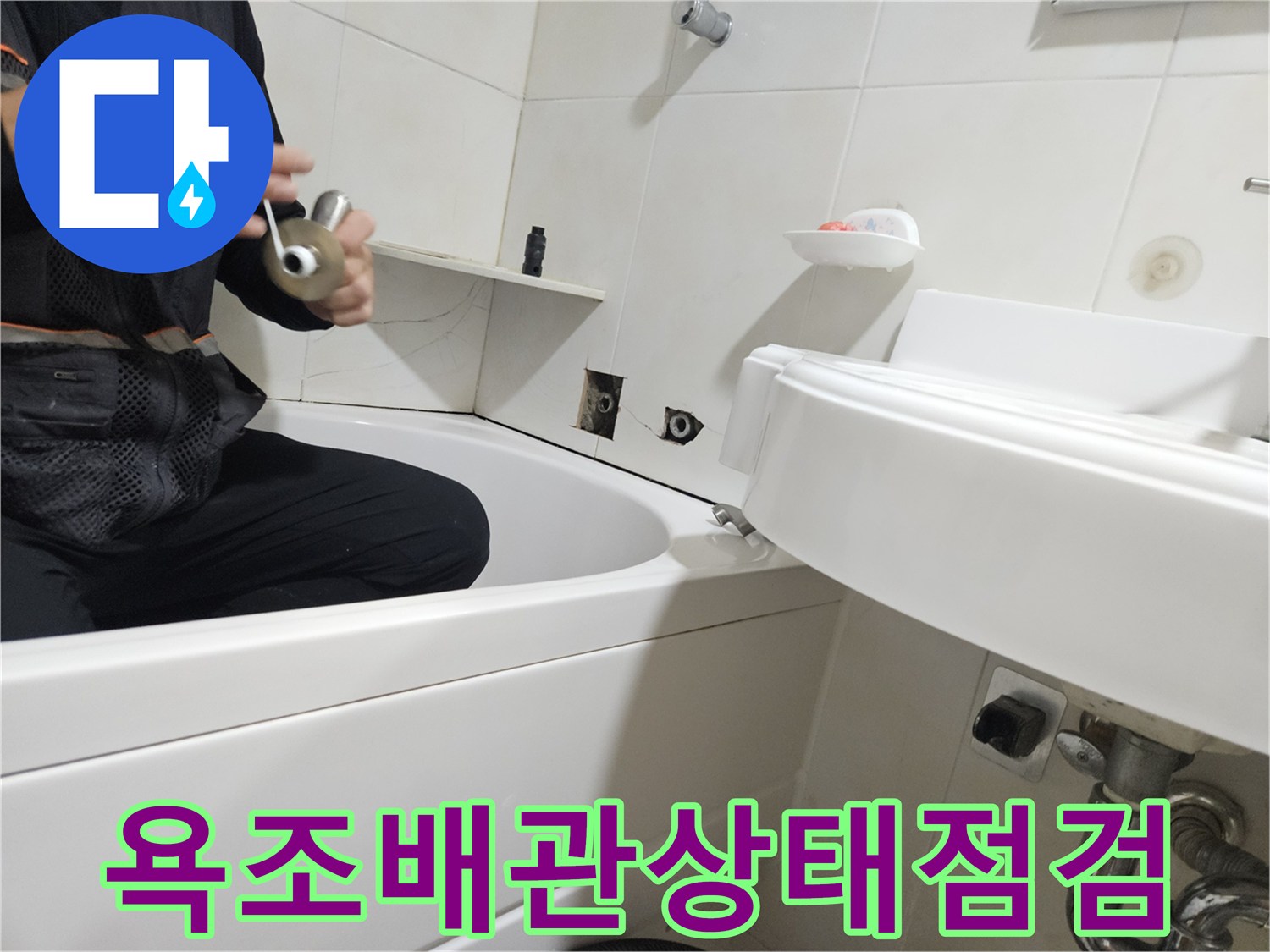 욕조 하부의 세면대 배관 연결 부위를 점검하는 모습입니다.