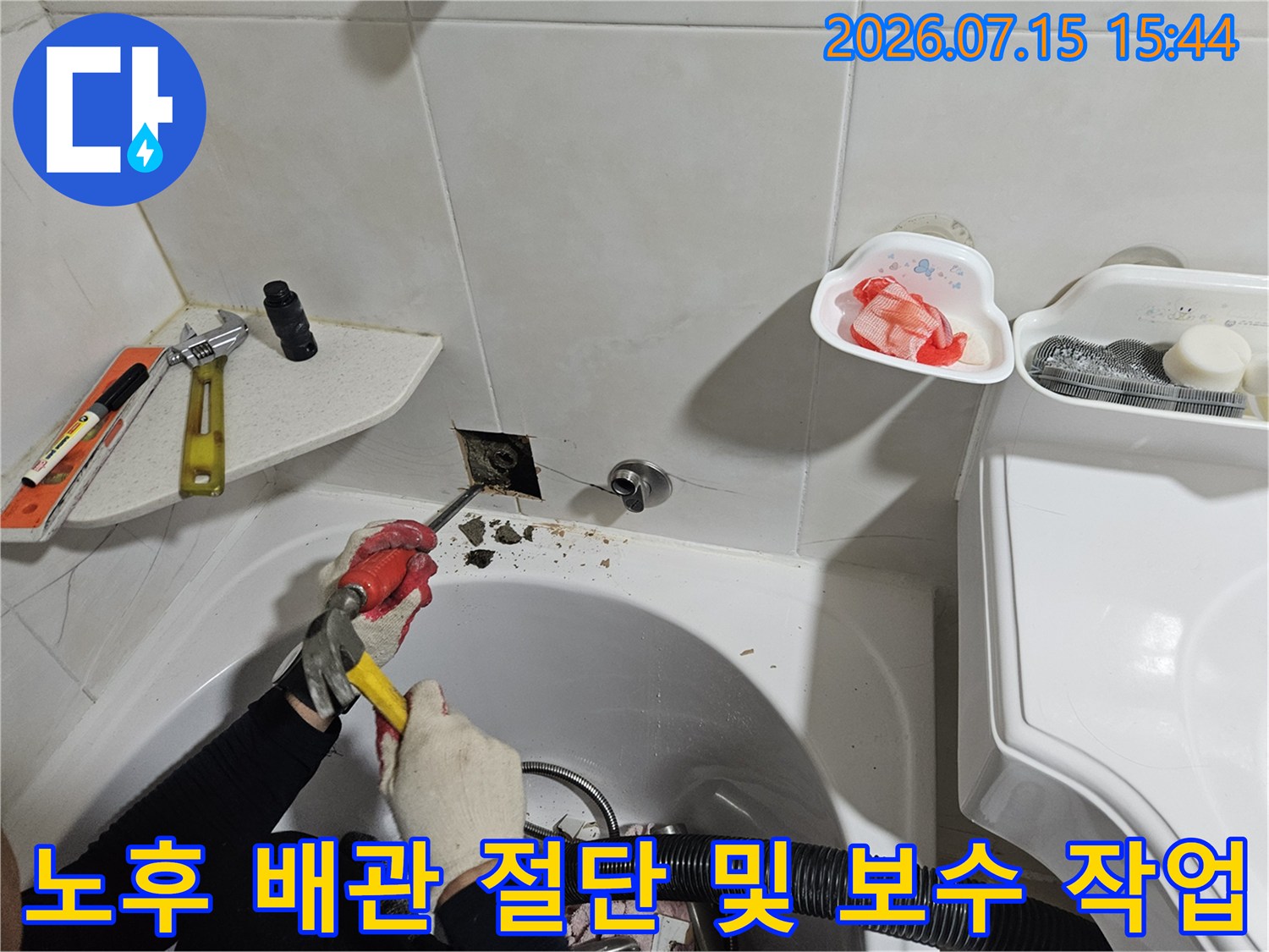 전문 도구를 사용하여 세면대 하부의 낡은 온수 배관을 교체하는 공사 과정