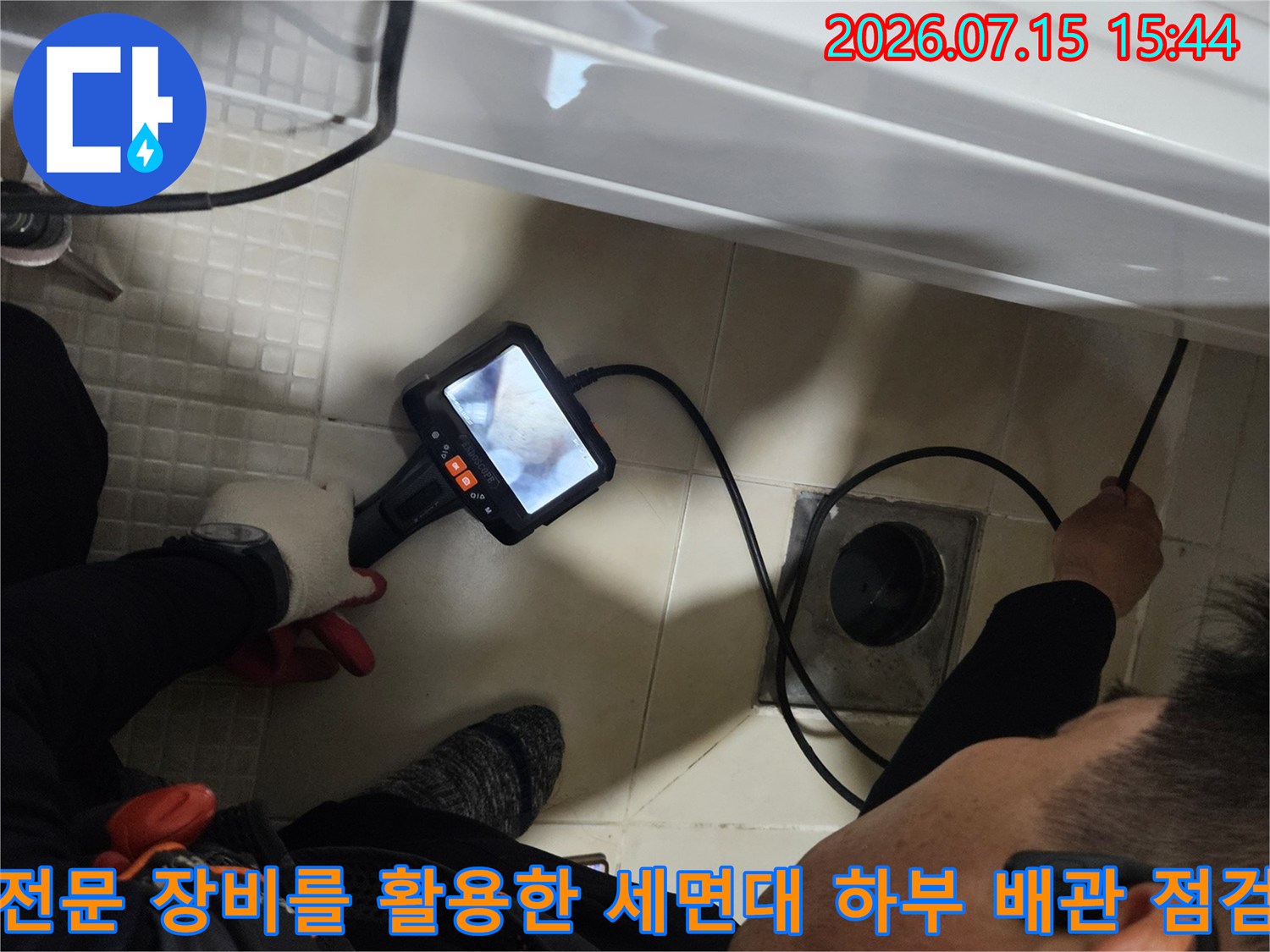 청음기 장치를 연결하여 세면대 아래쪽 누수 지점을 정밀하게 파악하는 장면입니다.