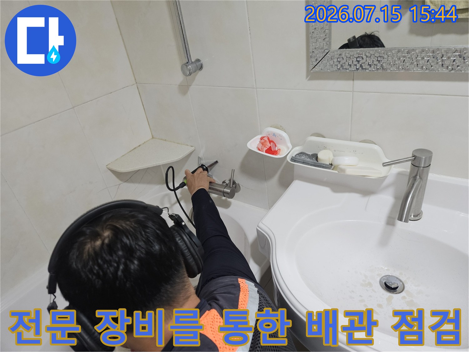 청음식 탐지기를 사용하여 세면대 아래 수도 배관의 누수 여부를 정밀하게 확인하는 과정