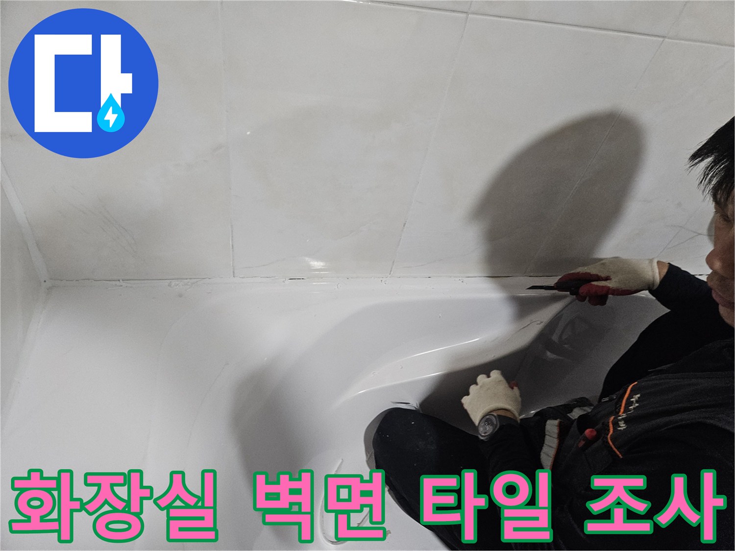 하얀색 욕실 타일과 욕조의 연결 부위를 점검하는 모습