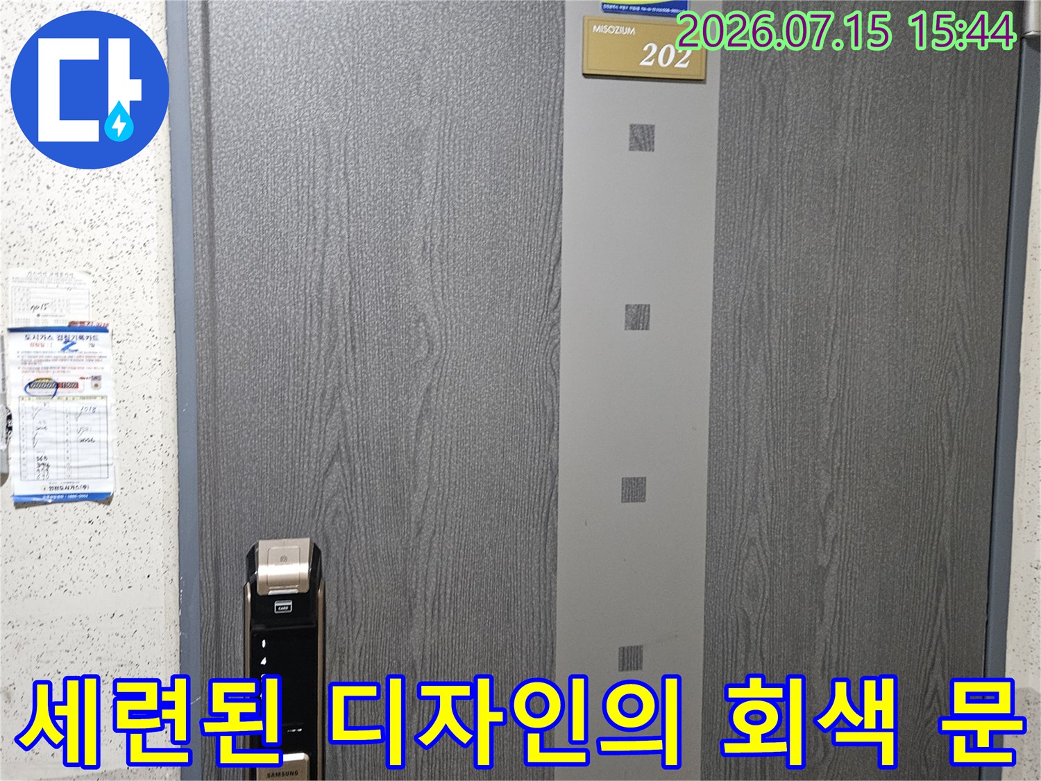 회색 우드톤 패턴이 들어간 현관문과 전자기기 도어록