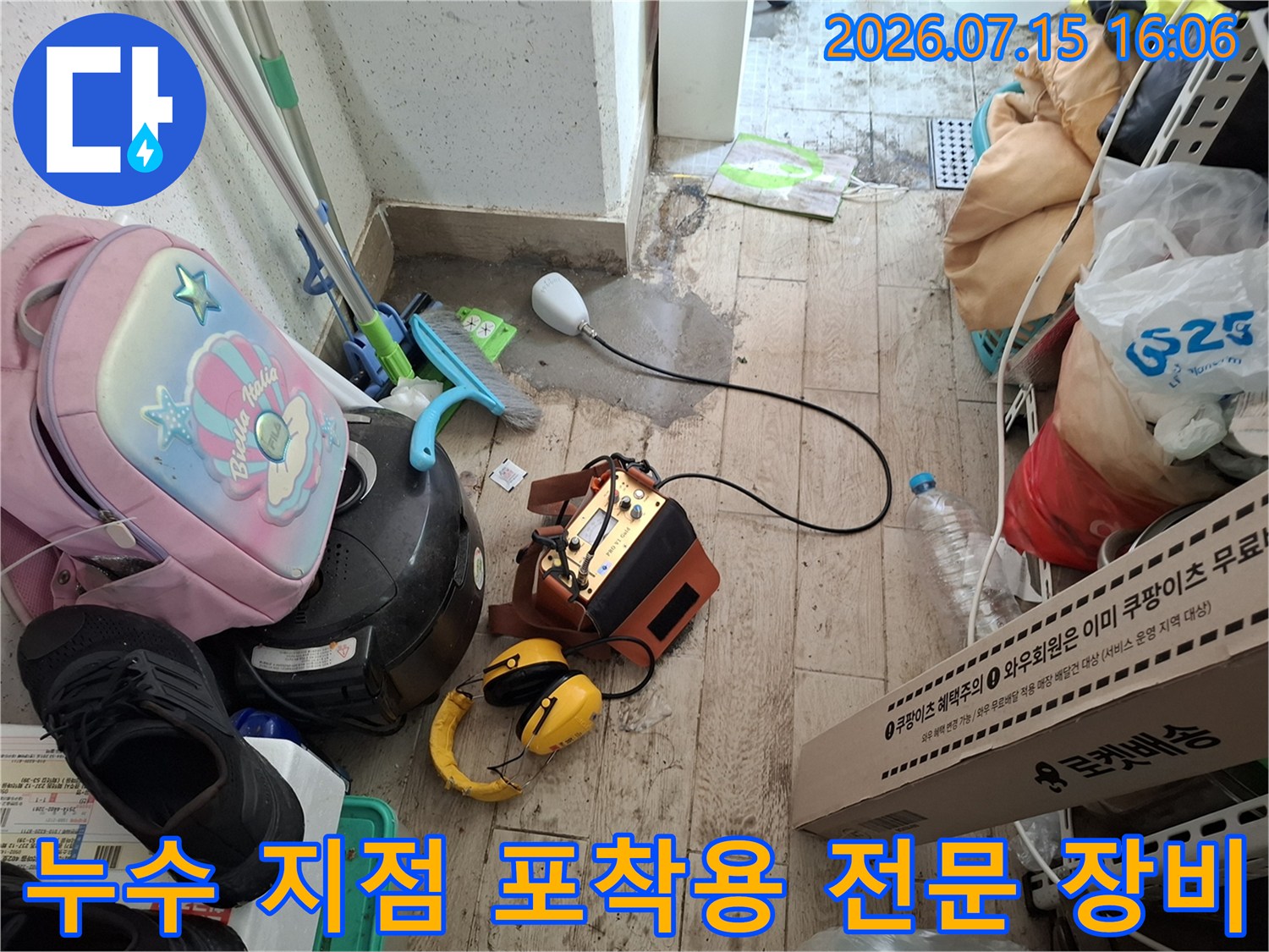 갈색 외형의 누수 탐지 본체와 노란색 헤드셋-센서가 연결된 장면