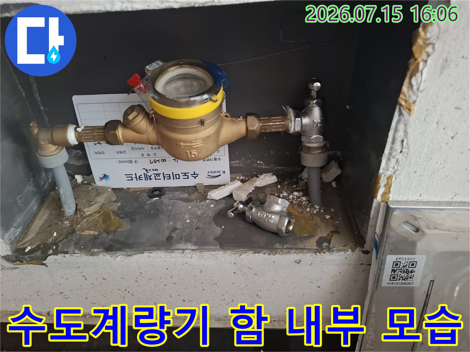 금속제 수도계량기와 연결된 배관-밸브가 설치된 계량기함 내부 사진