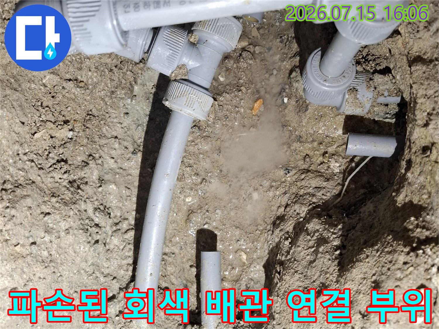 땅속에서 발견된 파손된 회색 수도 배관-연결 부품과 절단된 배관 모습