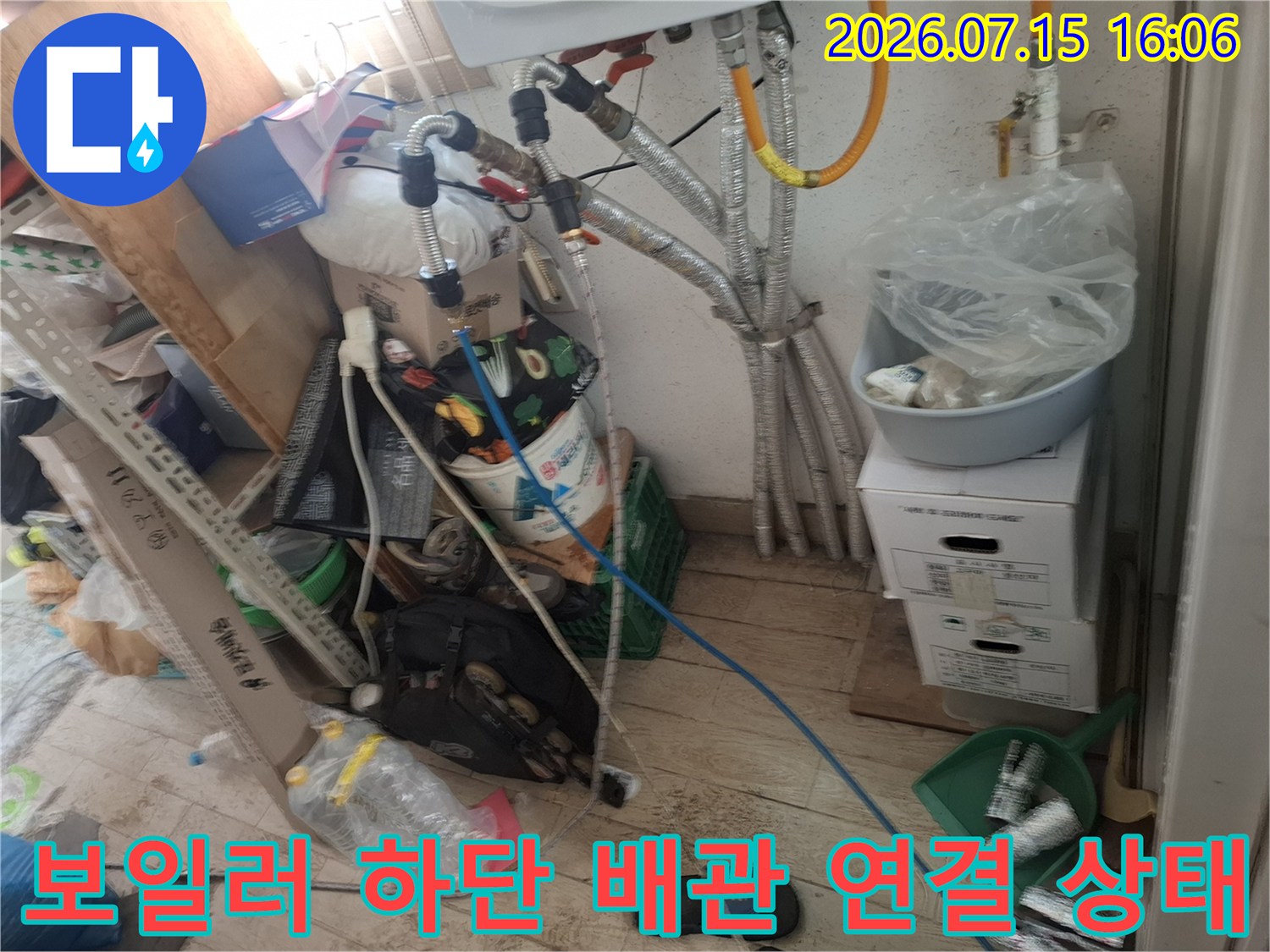 보일러 아래쪽에 복잡하게 얽혀 있는 은색 보온재 배관과 파란색 호스-누수 점검 모습