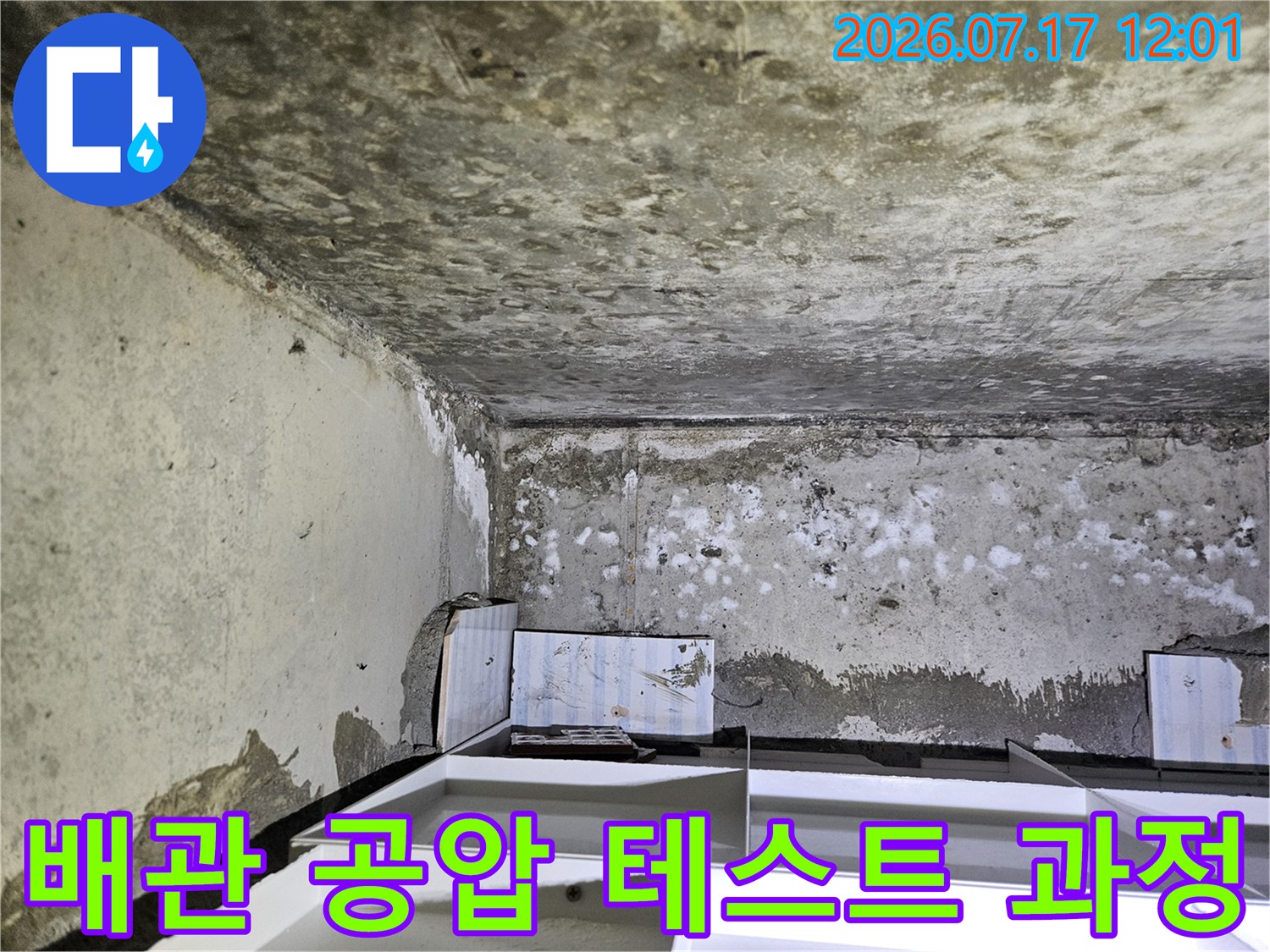 화장실 천장 안쪽 배관 부위에 설치된 압력 측정 게이지와 노출 배관
