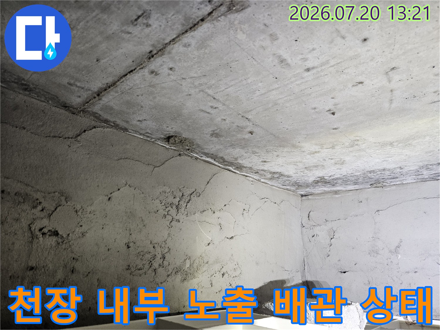 먼지가 쌓인 거친 콘크리트 천장과 얽힌 설비 구조물