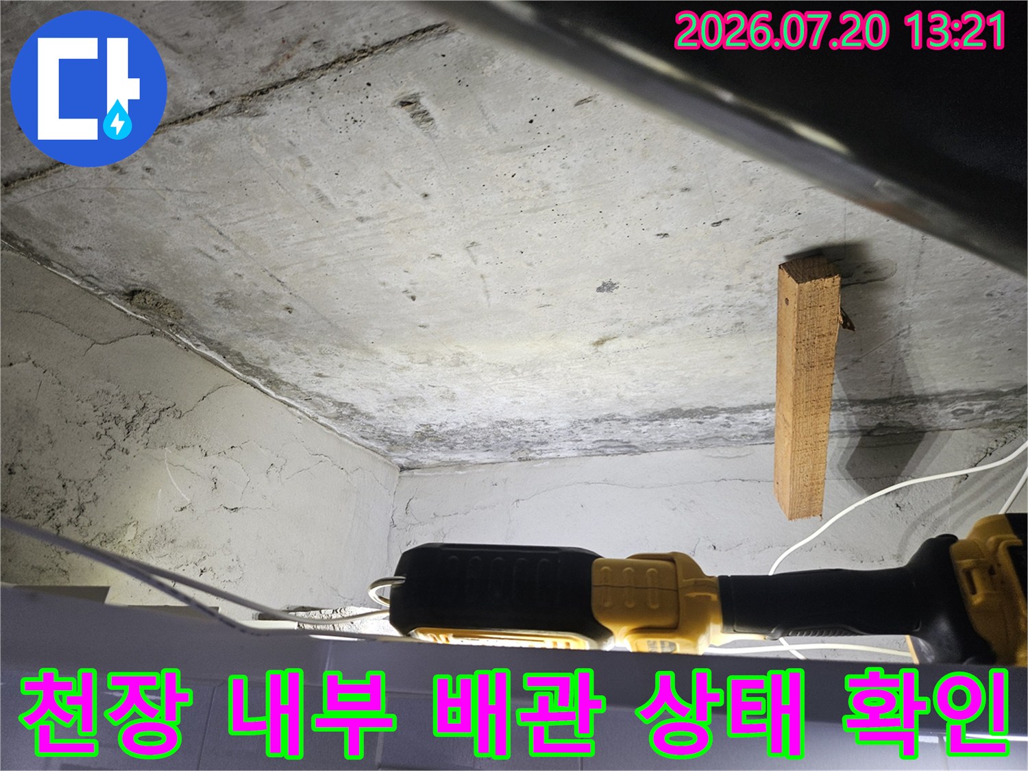 어두운 천장 안쪽에서 누수가 의심되는 배관 경로를 면밀히 조사하는 현장