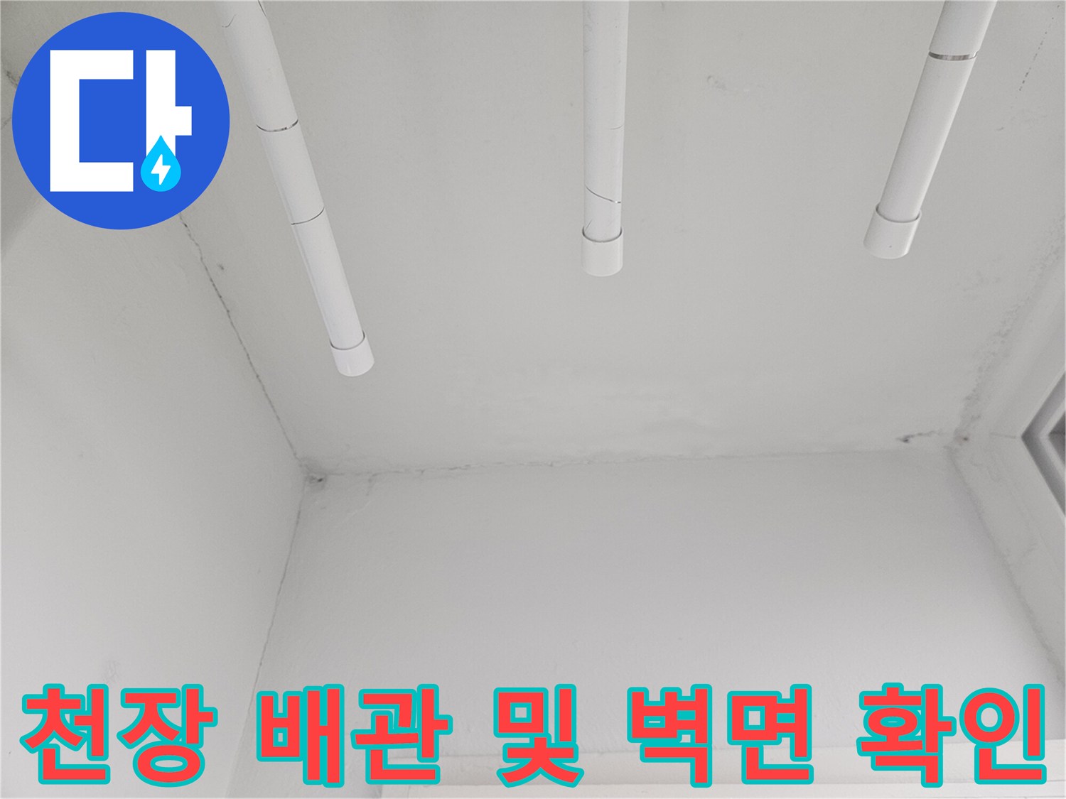 천장에 설치된 흰색 배관의 연결 상태와 주변 벽면