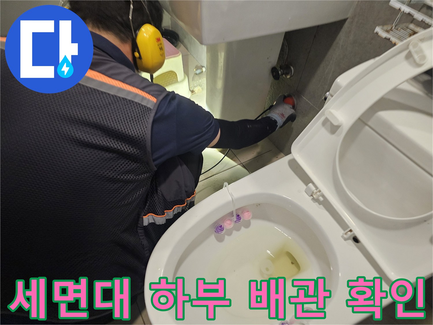 변기와 세면대 사이의 수도 배관 연결 상태를 점검하는 엔지니어