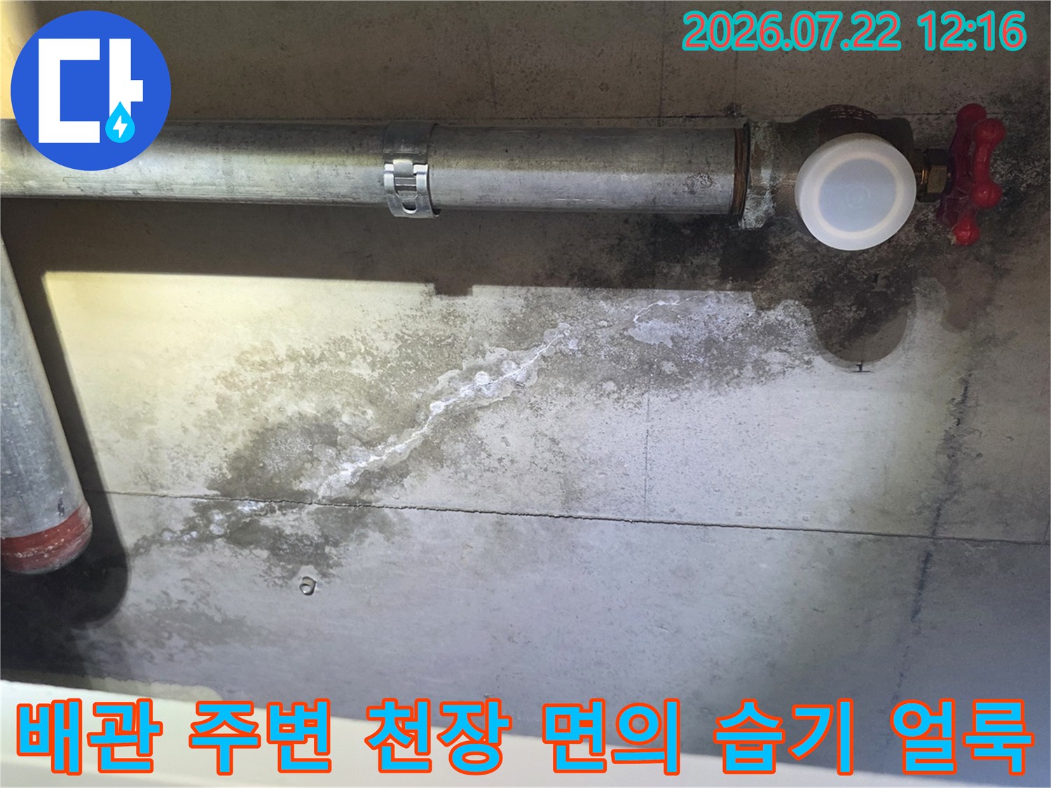 금속 배관-빨간색 밸브와 연결된 부위 주변으로 물이 스며들어 변색된 콘크리트 천장