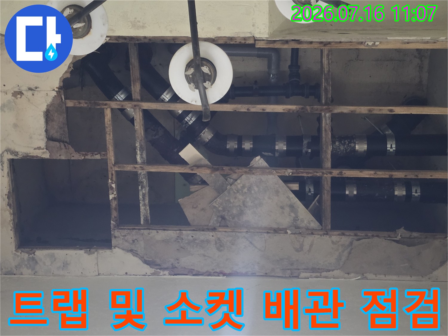 천장 안쪽의 복잡한 배관 트랩과 소켓 연결 부위를 세밀하게 살피는 장면