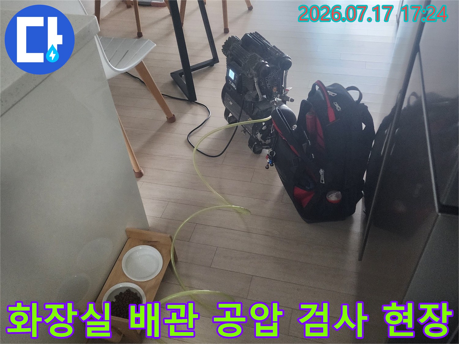 공압 검사 장비와 노란색 호스를 연결하여 화장실 배관의 압력을 체크하는 모습