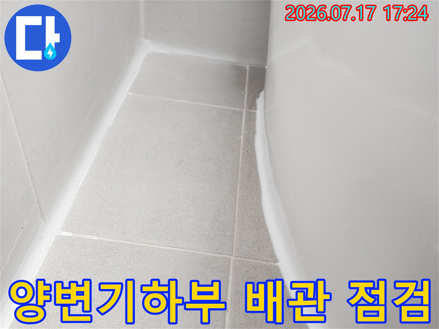 양변기 아래쪽으로 노출된 배관과 연결 부위를 점검하는 모습