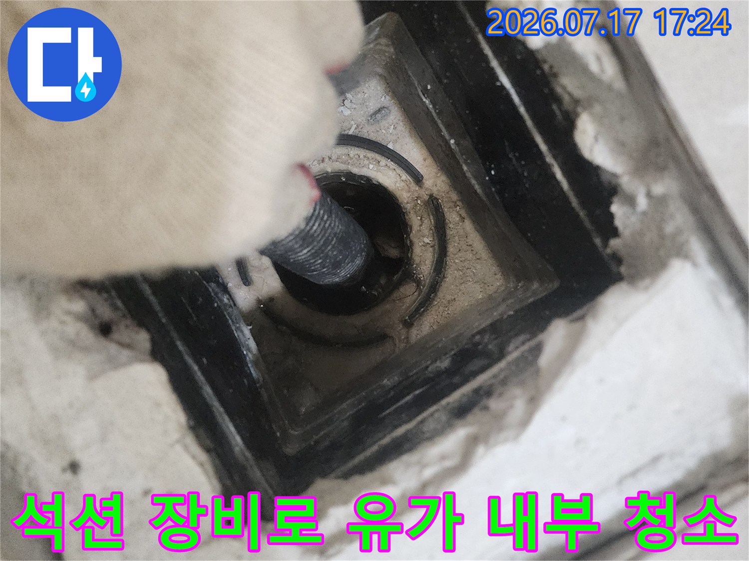 유가를 탈거하고 석션 호스로 배수구 안쪽을 깨끗하게 비우는 장면
