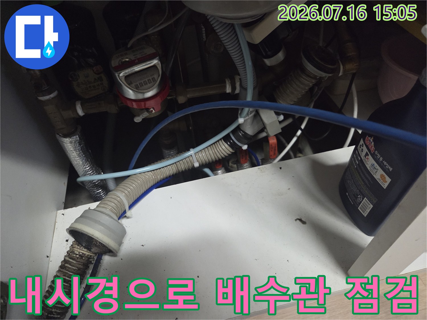 싱크대 하부장 내부에서 내시경 장비를 사용하여 배수관을 검수하는 모습