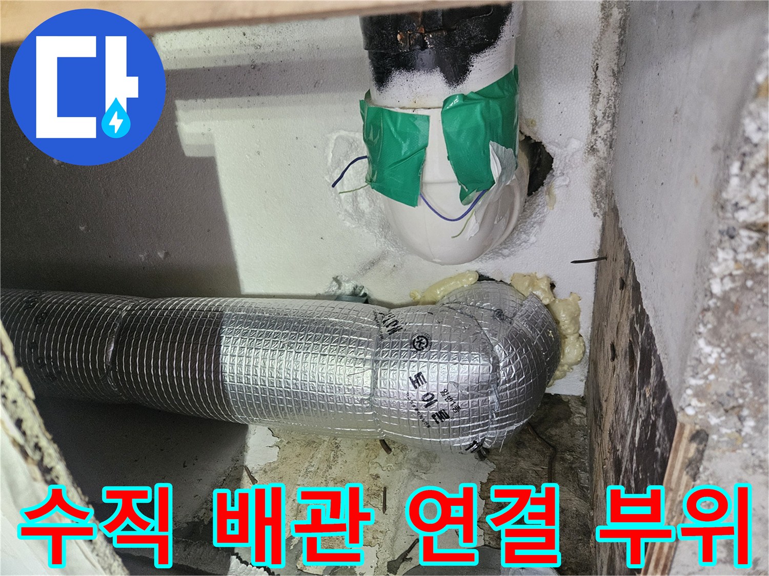 초록색 테이프로 고정된 수직 배관과 은박 보온재 배관의 접점