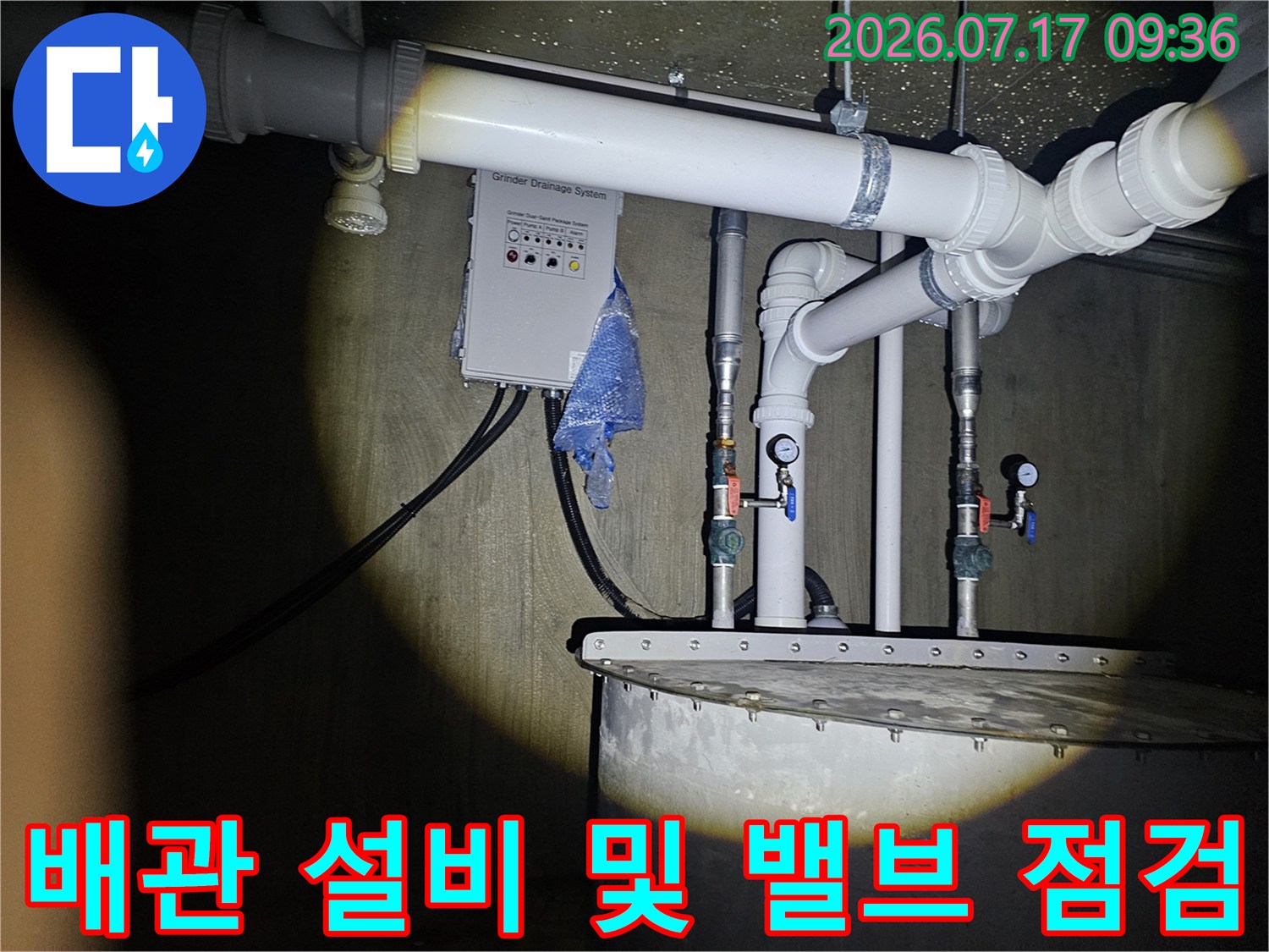 상가 내부의 수도 배관 시스템과 연결된 밸브류를 정밀하게 조사하는 엔지니어의 작업 모습