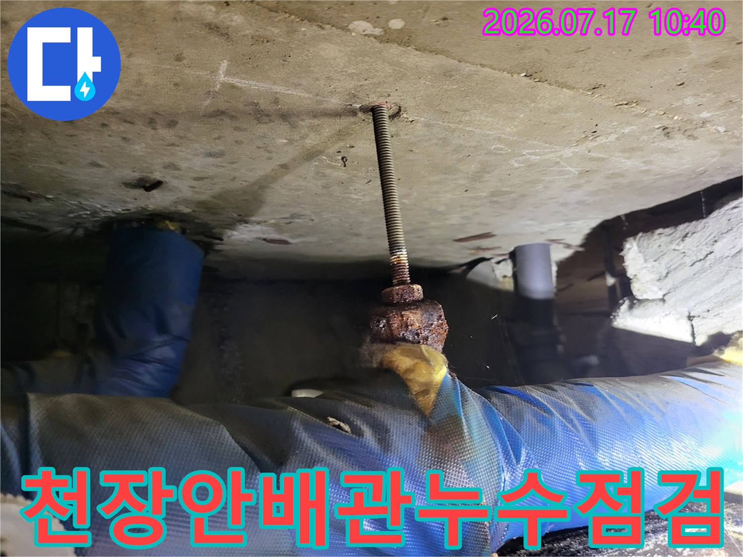 천장 안쪽의 노출된 배관과 전산볼트 부근을 세밀하게 점검하는 모습
