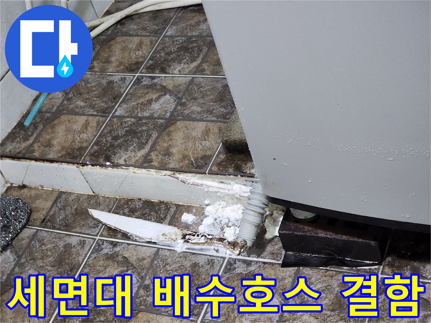 세면대 하부의 낡은 배수 호스와 주변 방수층 파손 상태를 보여주는 사진