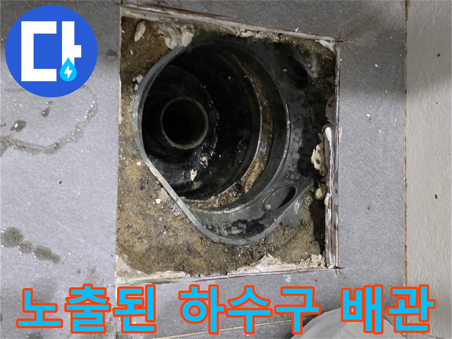배수구 주변-물에 젖은 바닥면과 노출된 배수관 구조