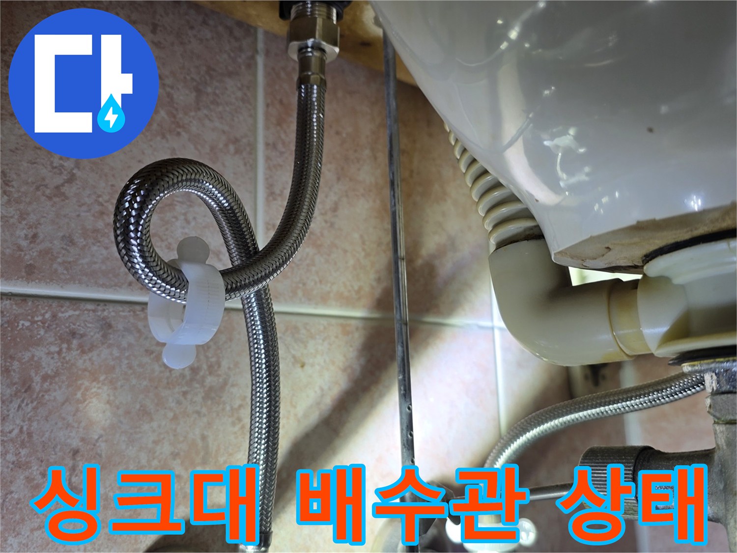 싱크대 하부-배수 호스와 금속 자재 점검 중인 모습