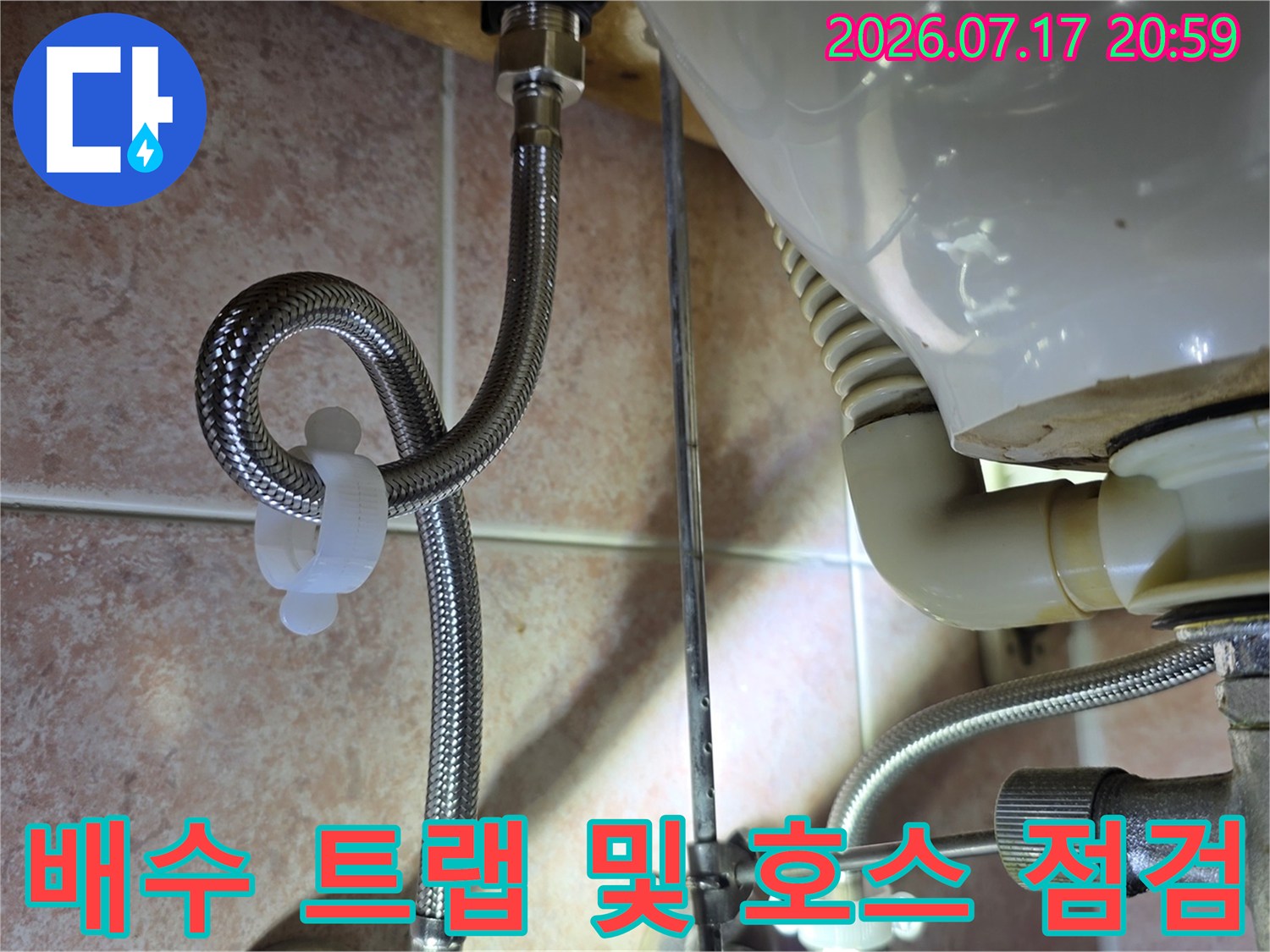 싱크대 하부 배수관 연결 부위와 주름호스를 확인하는 장면