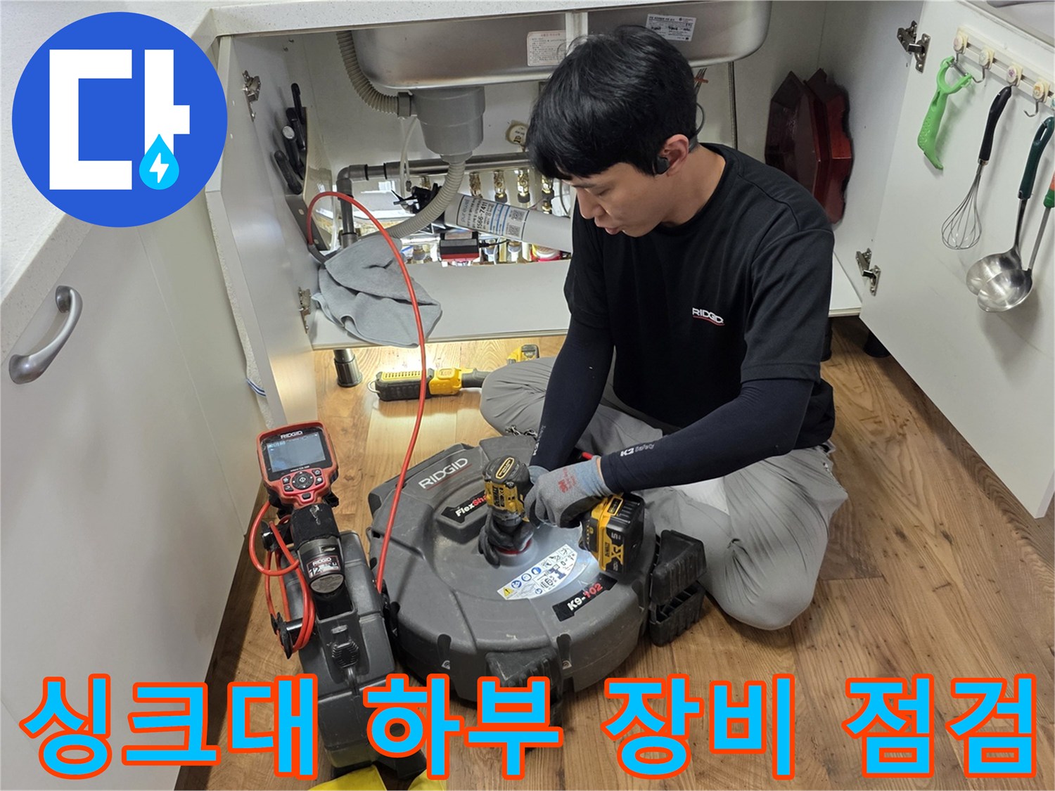 싱크대-하부장-내부에서-관로탐지기를-사용하여-배관을-조사하는-모습