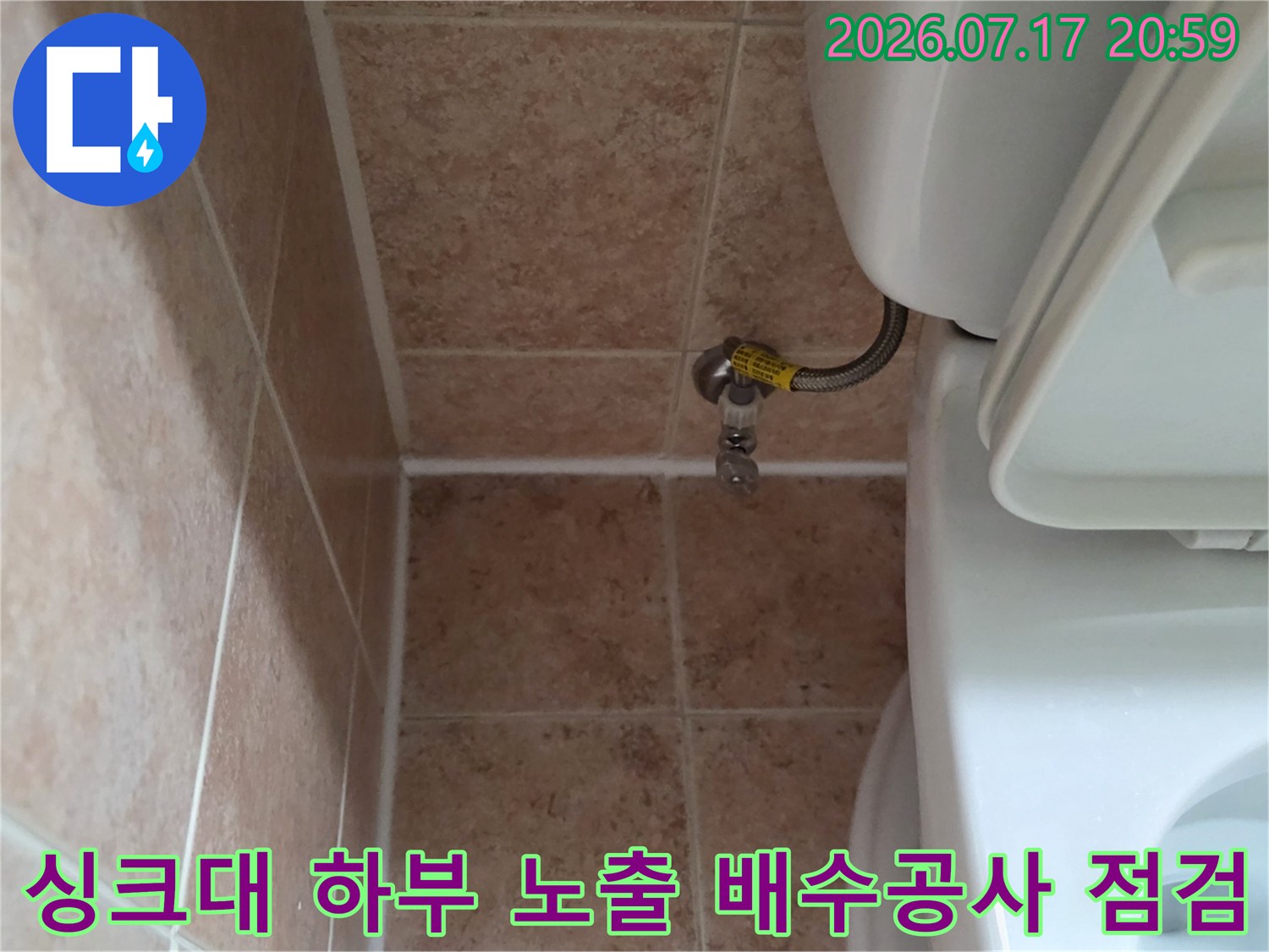 타일벽과 인접한 싱크대 아래 배수관 및 밸브 시스템 확인